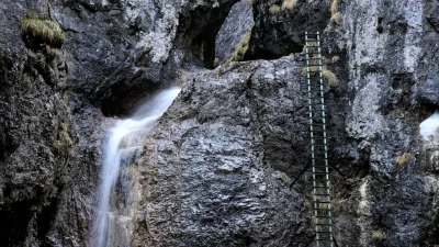 Žebřík podél Velkého vodopádu ústí do úzké skalní soutěsky plné dřevěných lávek